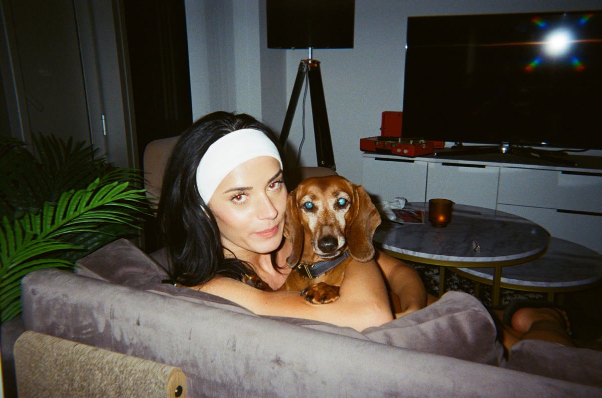 Lucy on the sofa at night with an older dachshund snuggled on her chest, caught on film flash
